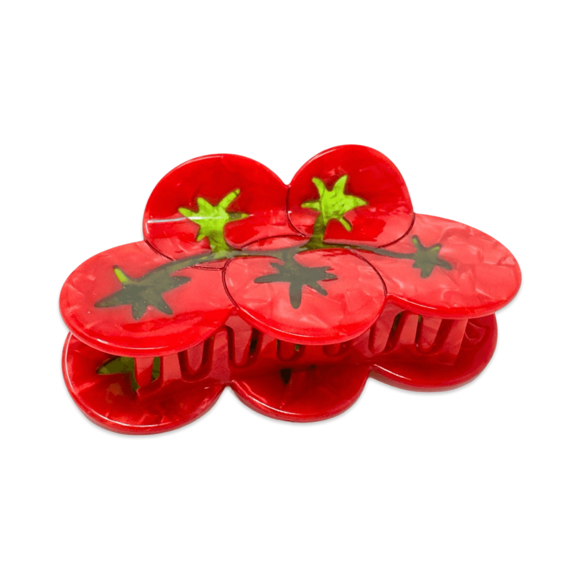 Red plastic tomato-shaped hair accessory with green stems on a white background